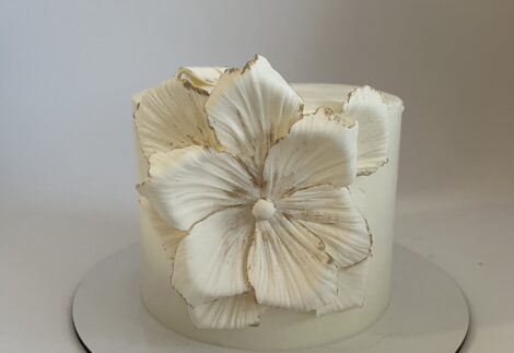 کیک تولد گل سفید مینیمال با تزئین گل دست‌ساز و لبه‌های طلایی